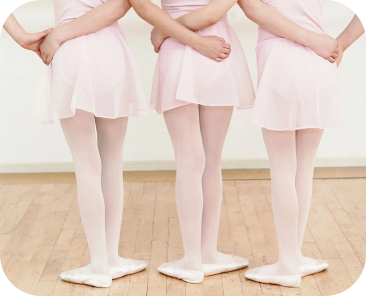 Three girls in pink dresses and white tights