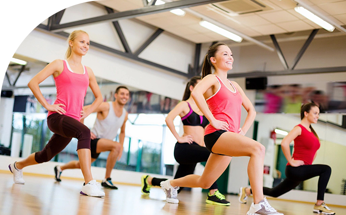 A group of people in the gym doing different exercises.